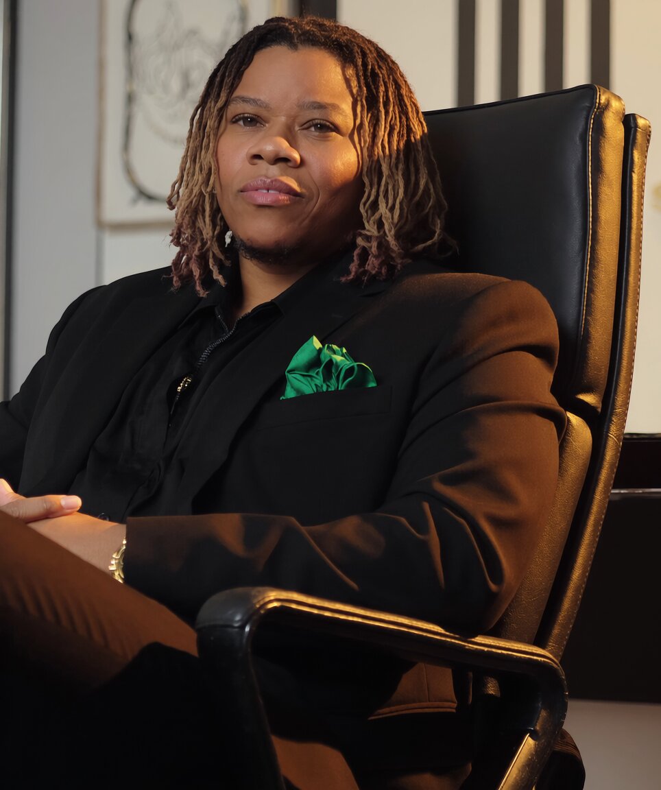 BOSS UP founder seated in a black leather office chair